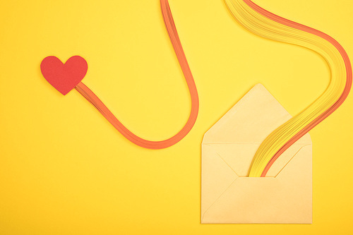 top view of open envelope with rainbow and heart sign on yellow background