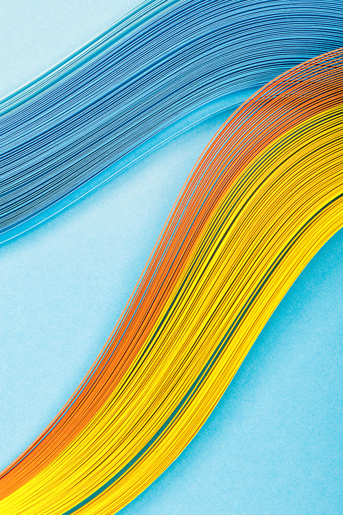 top view of yellow, orange and blue abstract lines on blue background