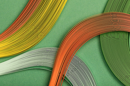 close up of yellow, orange and green abstract lines on green background
