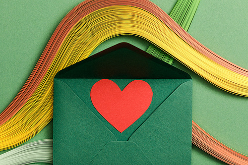 top view of multicolored abstract lines on green background with green opened envelope and heart sign