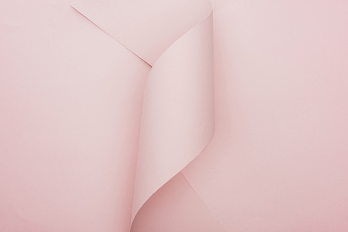 top view of pink paper swirl on pink background