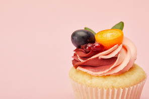 sweet cupcake with cream and fruits isolated on pink
