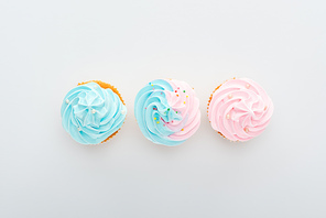 top view of delicious colorful cupcakes with sprinkles in row Isolated On White