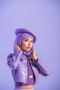 young woman dressed in doll style in beret posing on violet colorful background