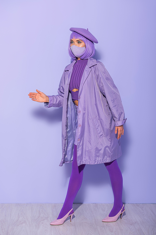 young woman dressed in doll style in medical mask and beret on violet colorful background