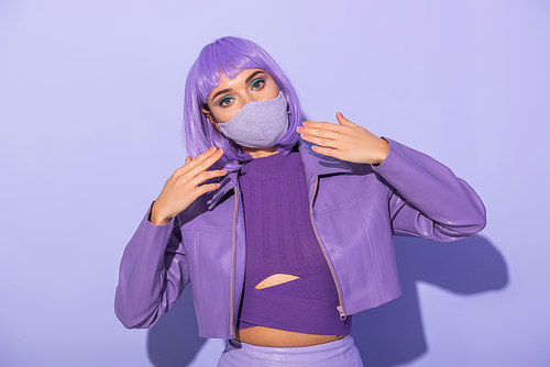 young woman dressed in doll style in medical mask with disco ball on violet colorful background