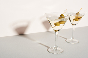 Martini cocktails with olives on white background