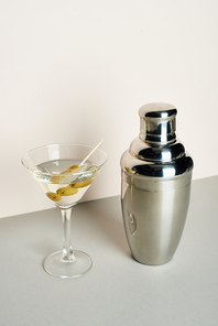 Classic martini with olives and shaker on white background