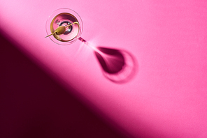 Top view of vermouth with olive on pink surface