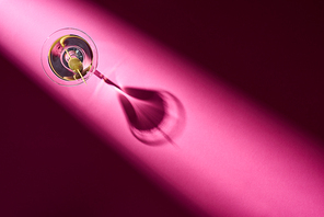 Top view of martini with olive on pink background with shadow