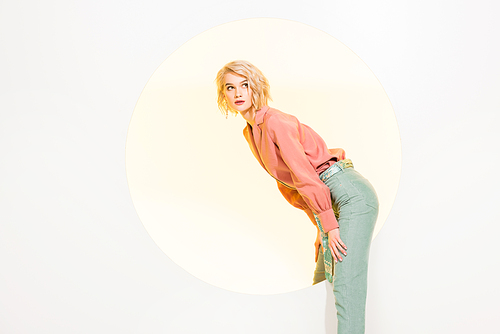 beautiful stylish young woman in colorful clothes posing on white with yellow circle and copy space