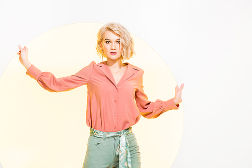beautiful stylish young woman in colorful clothes  and posing on white with yellow circle