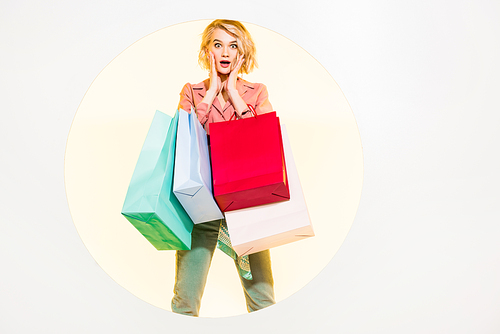 surprised stylish girl  and holding shopping bags on white with yellow circle