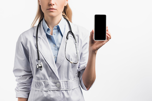 cropped view of nurse in white coat holding smartphone with blank screen isolated on white