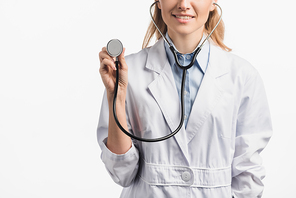 cropped view of happy nurse in white coat holding stethoscope isolated on white