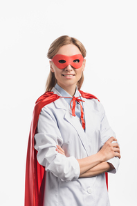 happy nurse in superhero mask and cloak standing with crossed arms isolated on white