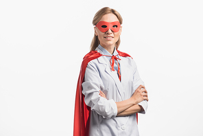 cheerful nurse in superhero mask and cloak standing with crossed arms isolated on white