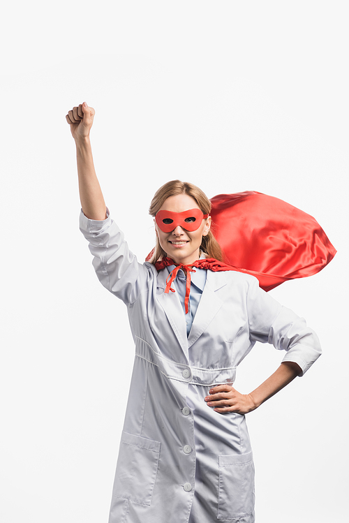 happy nurse in superhero mask and cloak standing with raised hand isolated on white