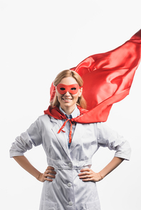 cheerful nurse in superhero mask and cloak standing with hands on hips isolated on white