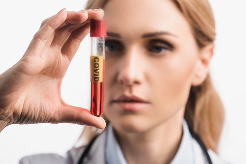 nurse holding test tube with covid lettering on blurred foreground isolated on white