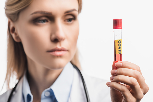 test tube with covid lettering in hand of nurse on blurred background isolated on white
