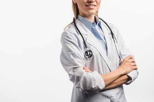 cropped view of joyful nurse in white coat standing with crossed arms isolated on white