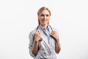 joyful nurse in white coat adjusting stethoscope isolated on white