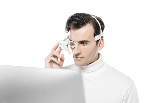 Cyborg in eye lens and headphones looking at computer on blurred foreground isolated on white