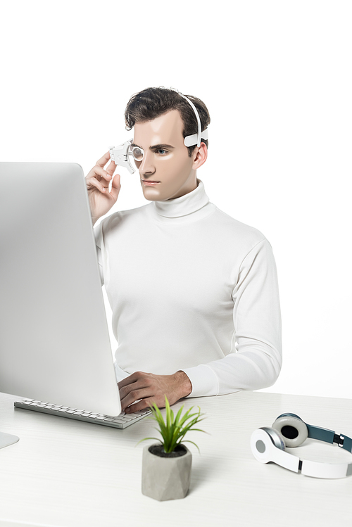 Cyborg in headphones using computer near headphones and plant on blurred foreground isolated on white