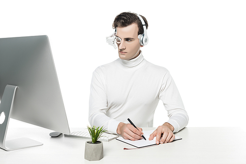 Cyborg man in eye lens and headphones writing on notebook near computer and plant isolated on white