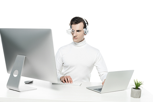 Cyborg using laptop and computer near plant on table isolated on white