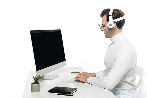 Cyborg in headphones using computer with blank screen near plant and notebook on table isolated on white