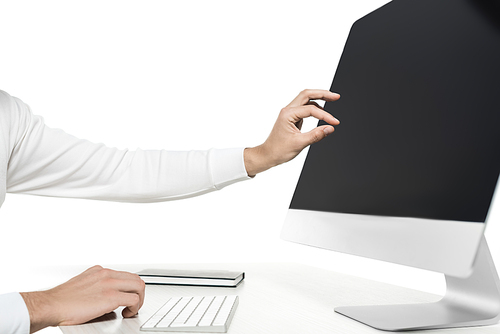 Cropped view of man touching blank screen of computer near notebook on table isolated on white