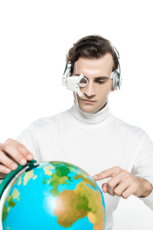 Cyborg man in eye lens and headphones pointing at globe on blurred foreground isolated on white