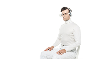 Cyborg man in headphones and eye lens  while sitting on chair isolated on white