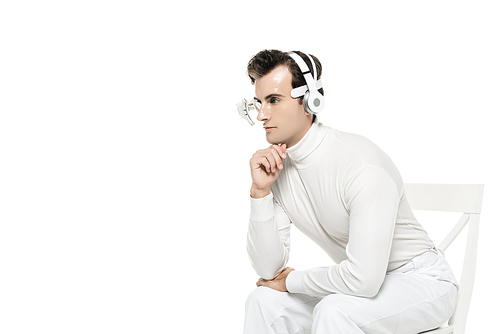 Cyborg in digital eye lens and headphones sitting on chair isolated on white