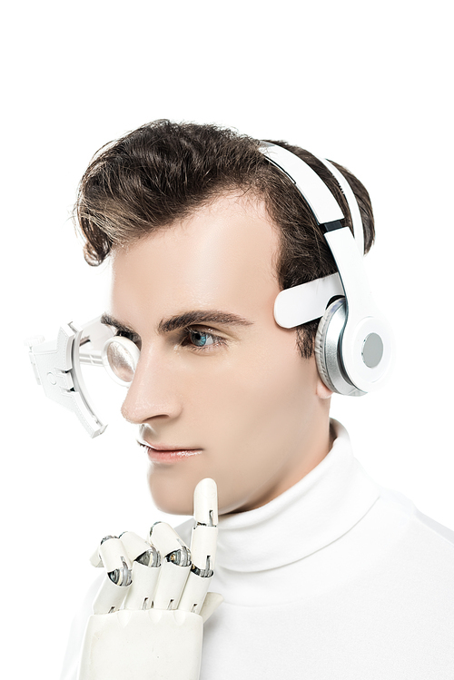 Cyborg in headphones and digital eye lens touching chin with artificial hand isolated on white