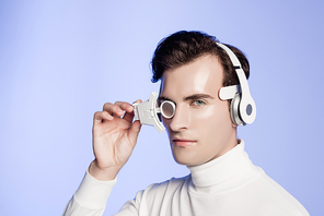 Cyborg in headphones and eye lens  isolated on blue