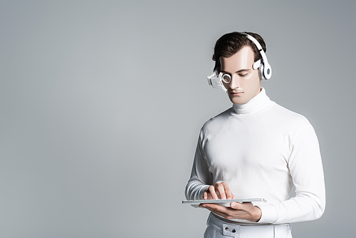 Cyborg man in headphones using computer keyboard isolated on grey with copy space