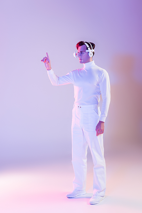 Cyborg in white clothes, eye lens and headphones pointing with finger up on purple background