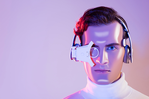 Portrait of cyborg in headphones and digital eye lens on purple background