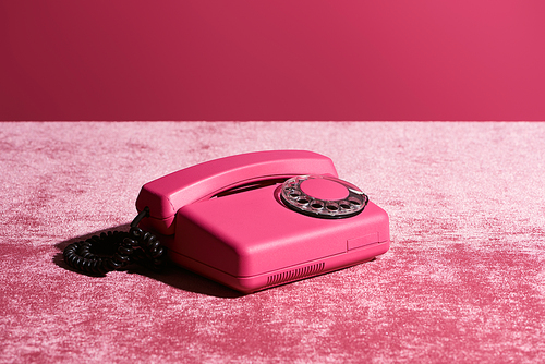 vintage phone on velour pink cloth isolated on pink, girlish concept