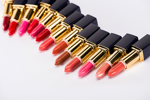 selective focus of assorted lipsticks in luxury tubes on white background