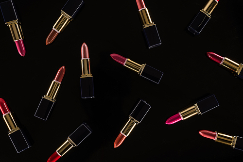 top view of assorted lipsticks in luxury tubes isolated on black