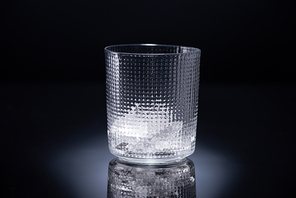 faceted glass with ice on black background