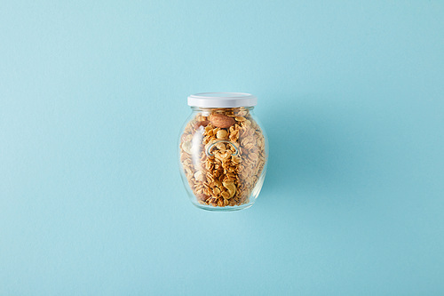 Top view of jar of granola on blue background