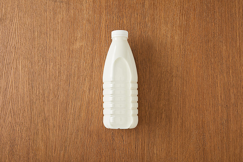 Top view of bottle of milk on wooden background