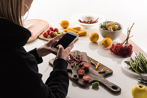 cropped view of photographer making food composition for commercial photography on smartphone
