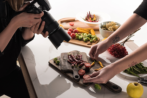cropped view of commercial photographers making photo shoot of food on digital camera