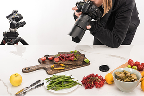 female photographer making food composition for commercial photography and taking photo on digital camera